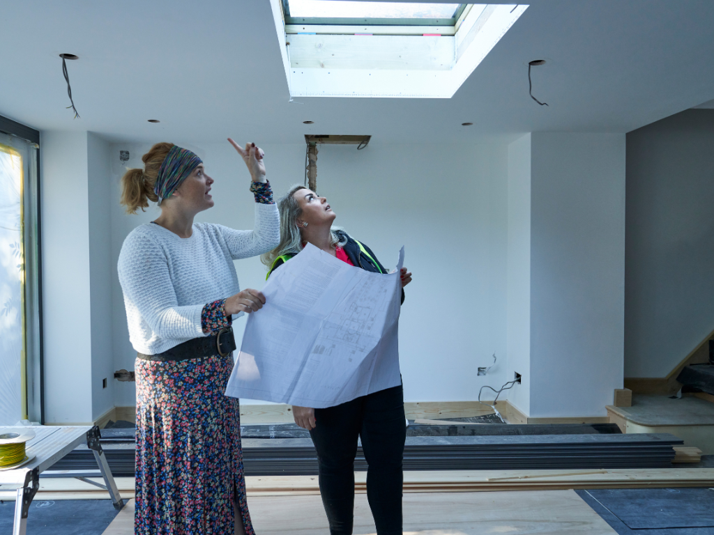 Homeowners reviewing house extension plans with a design and build specialist